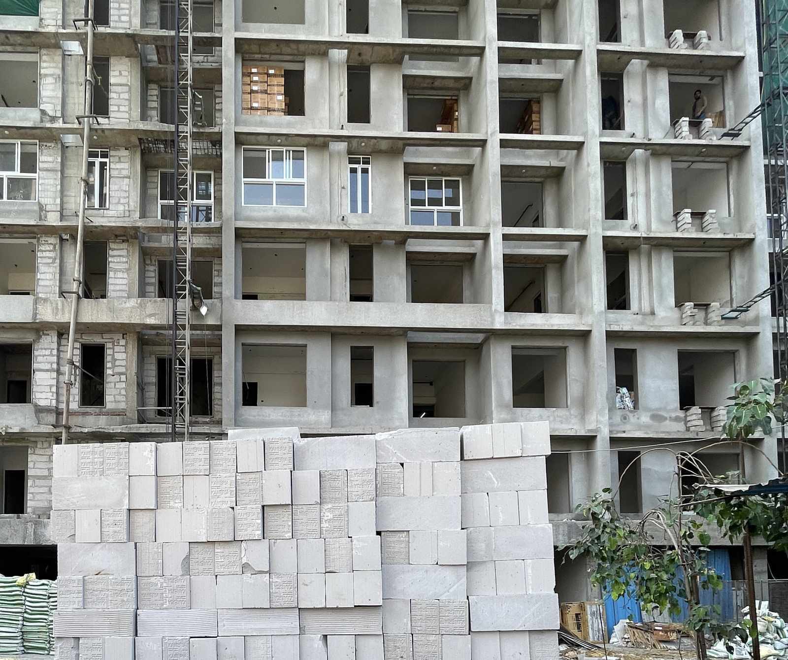 AAC blocks stacked on site in front of a building under construction
