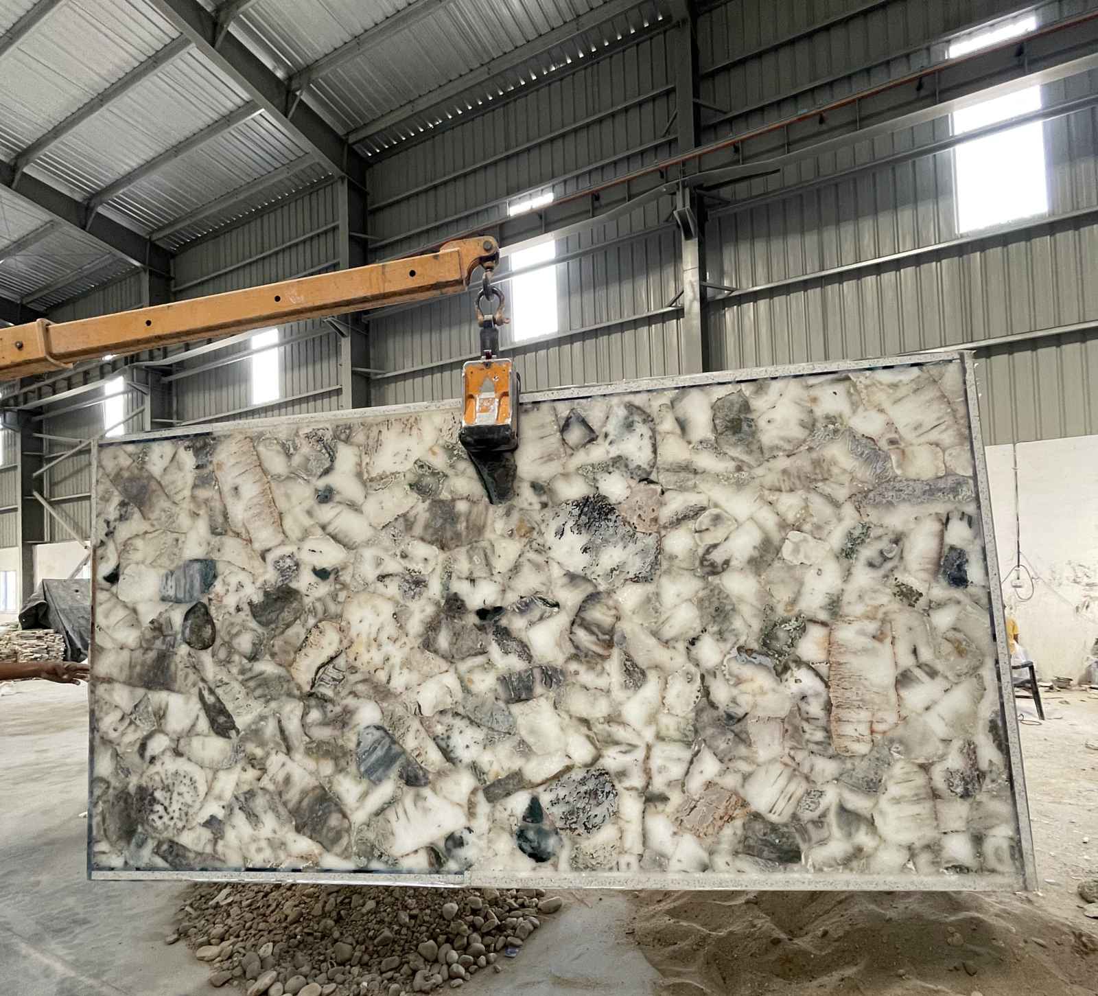 Engineered semi-precious stone slab lifted by a yard crane