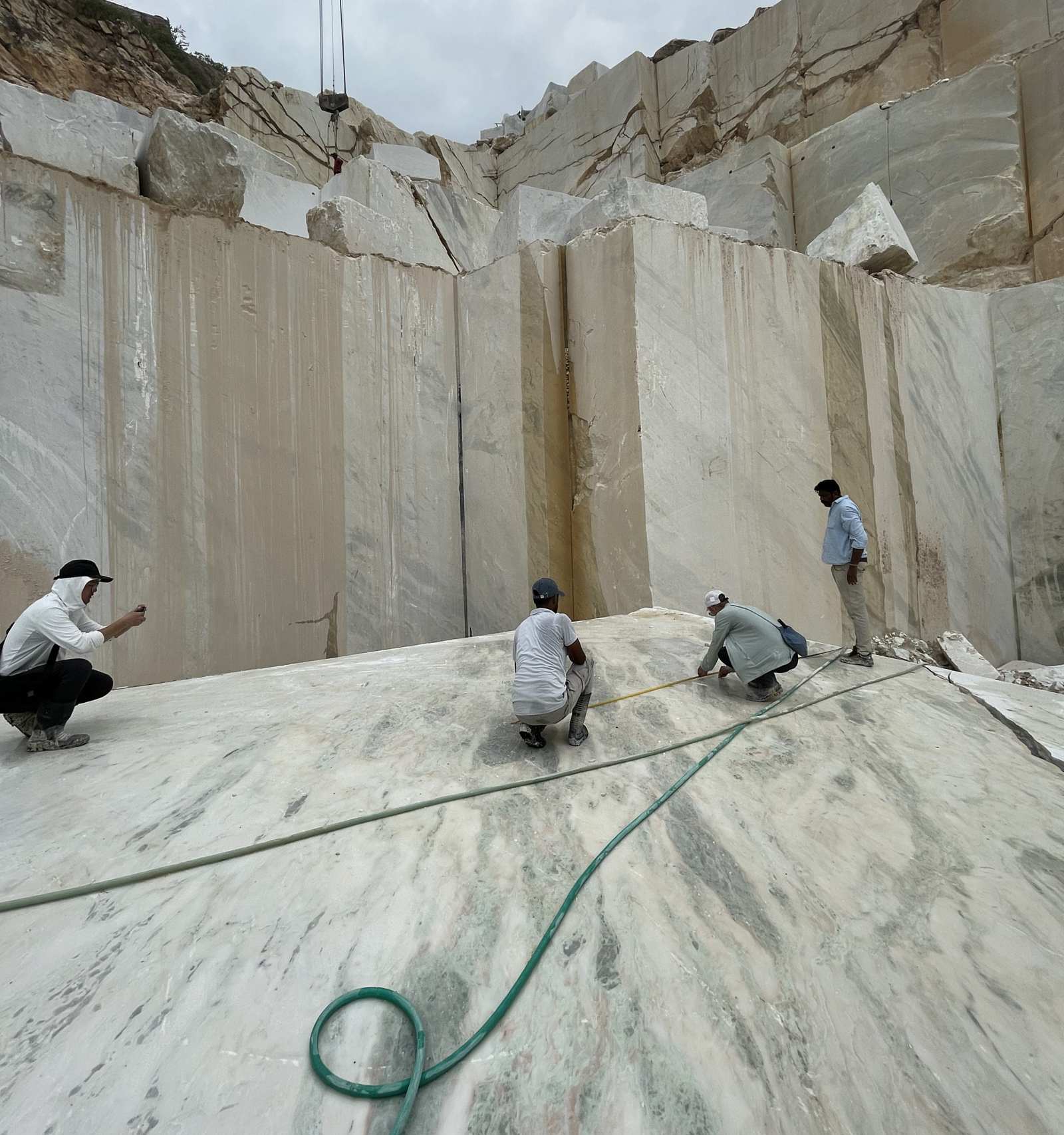People inspecting a cut stone floor inside a quarry